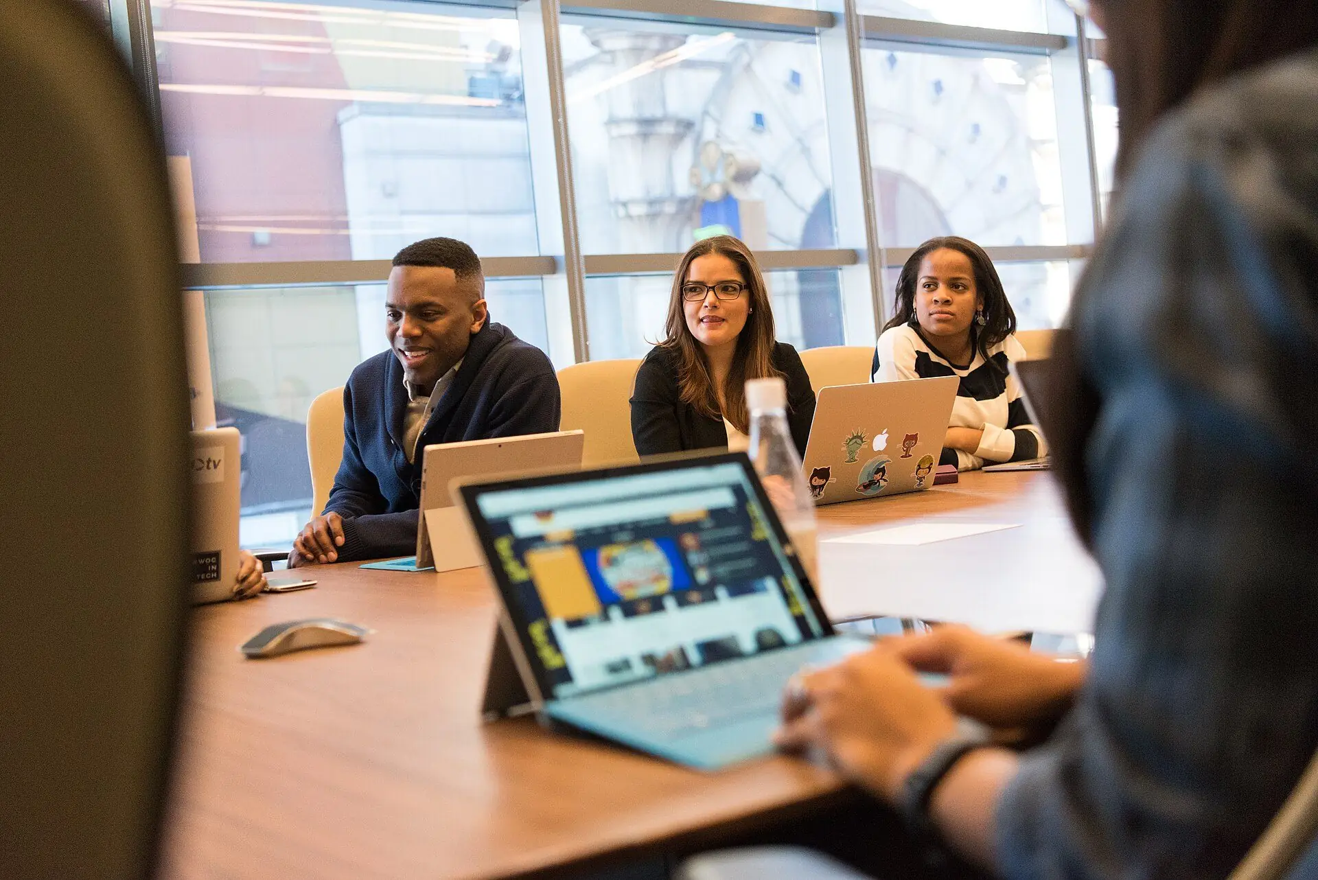 Equipe reunida em um escritório acompanhando uma operação no laptop